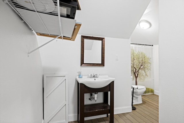 bathroom with hardwood / wood-style floors, a shower with shower curtain, toilet, and vanity