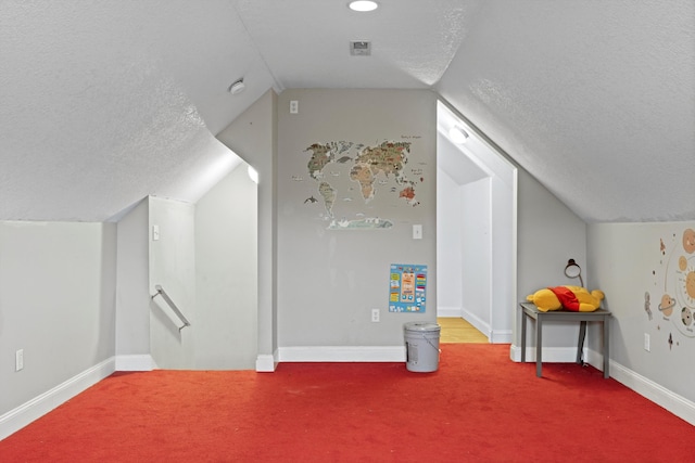 bonus room with carpet flooring, lofted ceiling, and a textured ceiling