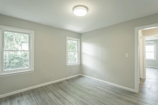 spare room with a healthy amount of sunlight and light wood-type flooring