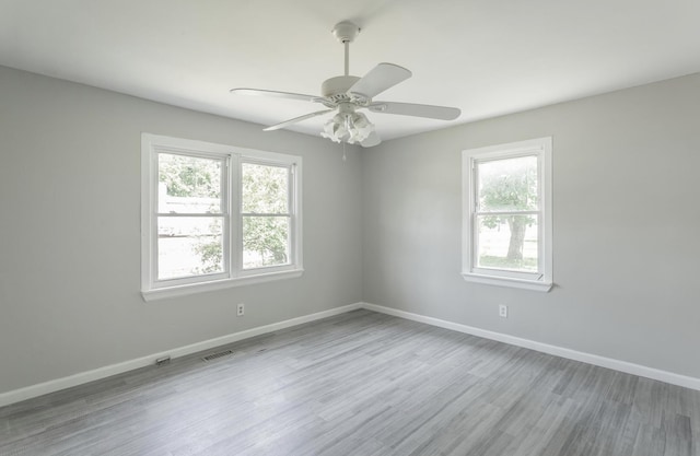 empty room with light hardwood / wood-style flooring, ceiling fan, and a wealth of natural light