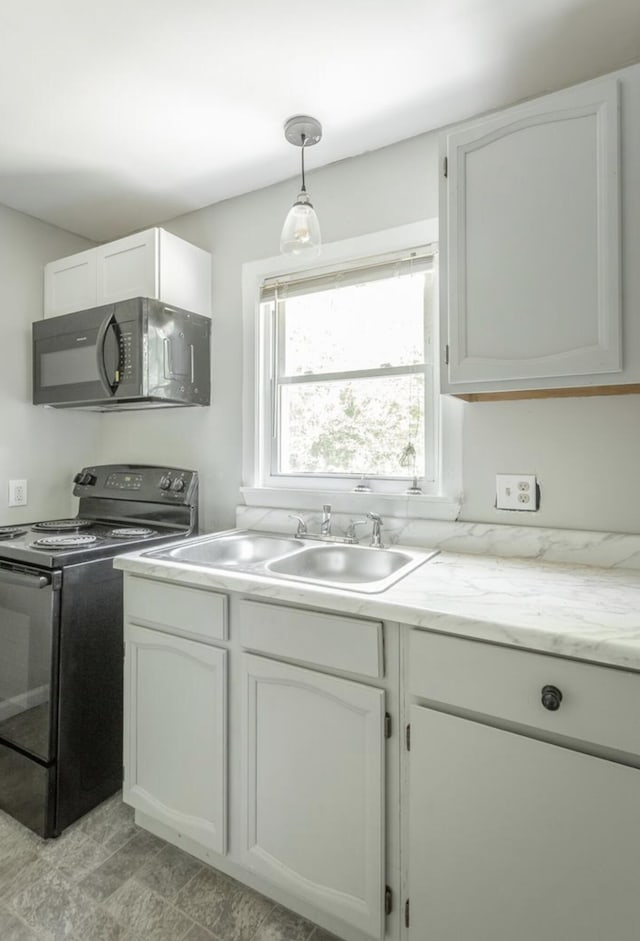 kitchen with white cabinetry, black appliances, sink, and hanging light fixtures