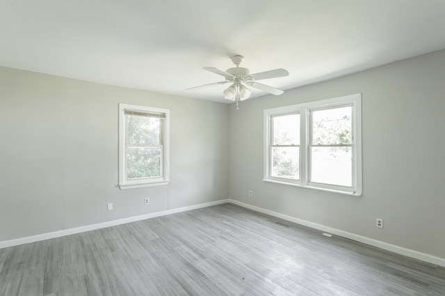 unfurnished room with ceiling fan, light wood-type flooring, and plenty of natural light