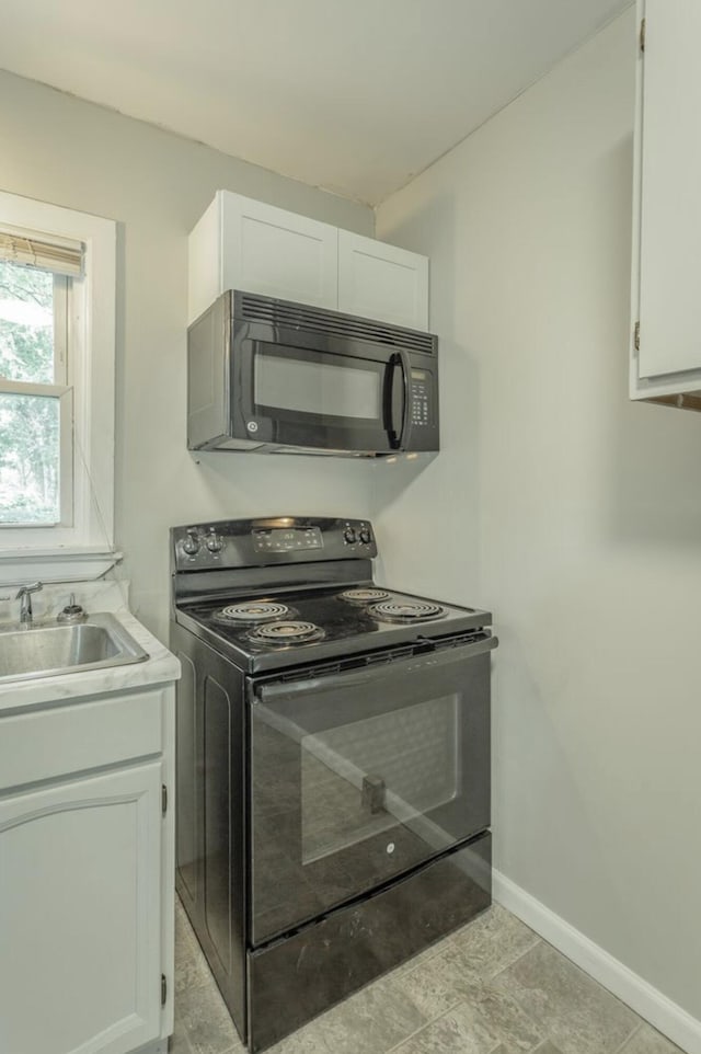 kitchen featuring black appliances, sink, and white cabinets