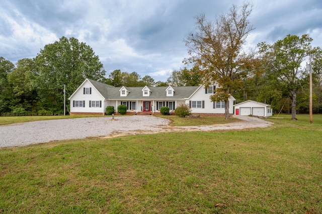 view of front facade with a front lawn, an outbuilding, a garage, and covered porch