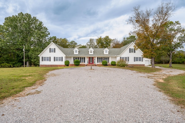 cape cod-style house with a front lawn, covered porch, and a garage