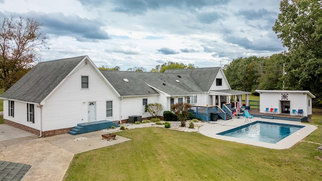 rear view of house featuring a patio, a lawn, and central AC unit