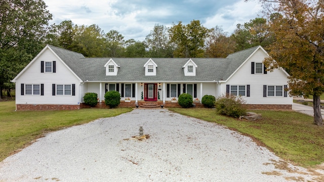 cape cod house featuring a front lawn and covered porch