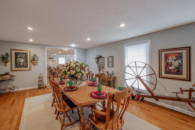 dining space featuring light hardwood / wood-style floors and a textured ceiling