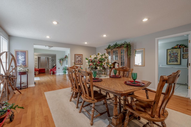 dining room featuring light hardwood / wood-style flooring and a textured ceiling