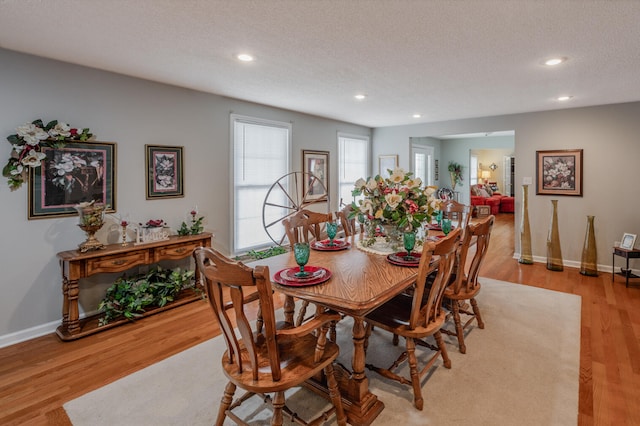 dining space with light hardwood / wood-style flooring and a textured ceiling