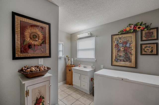 bathroom with vanity, a textured ceiling, and tile patterned flooring