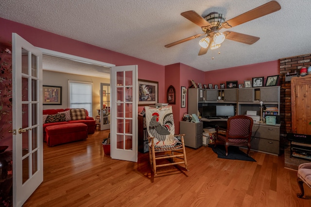 office area with light hardwood / wood-style floors, french doors, a textured ceiling, and ceiling fan