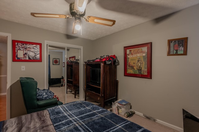 carpeted bedroom featuring a textured ceiling, a closet, and ceiling fan