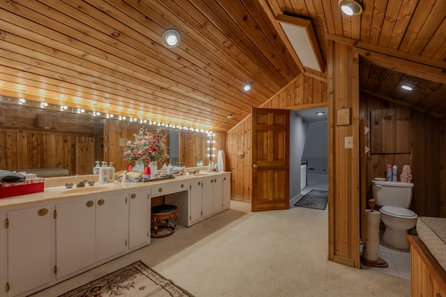 bathroom featuring wood ceiling, toilet, vaulted ceiling, wooden walls, and vanity