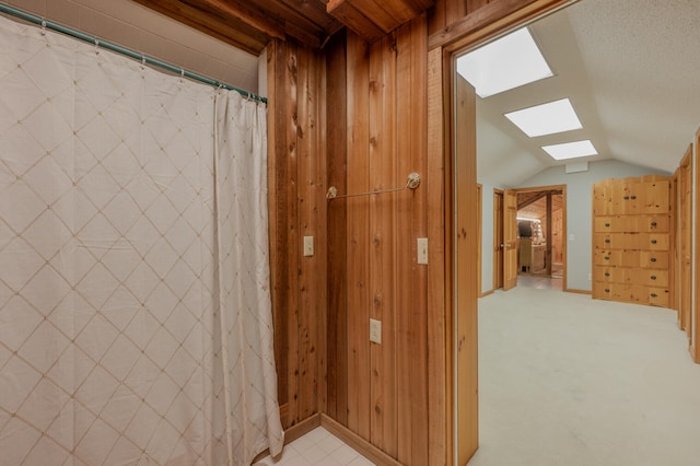 bathroom with wood walls and lofted ceiling