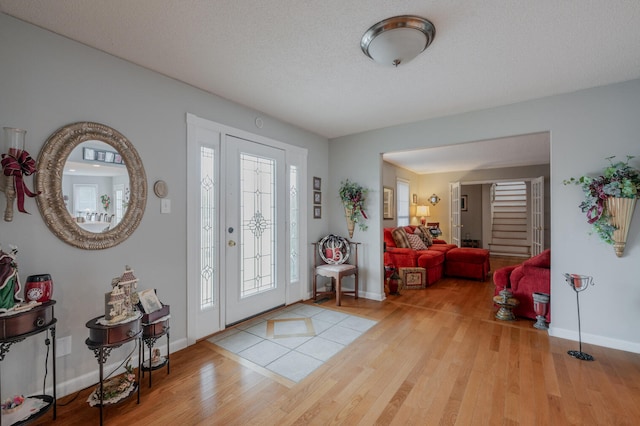 entrance foyer with a textured ceiling and light hardwood / wood-style flooring