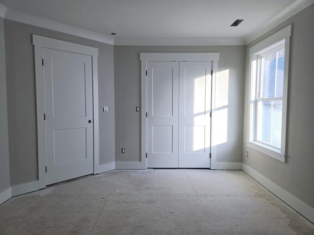 unfurnished bedroom featuring multiple windows, crown molding, and a closet