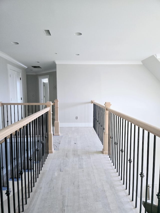 corridor featuring crown molding and light hardwood / wood-style flooring