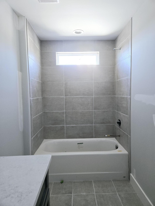 bathroom featuring tiled shower / bath, tile patterned floors, and vanity