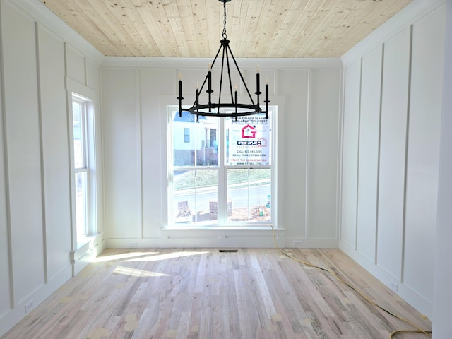 unfurnished dining area with wood ceiling, light hardwood / wood-style flooring, and a notable chandelier