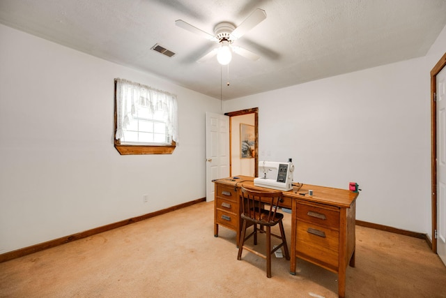 office featuring light carpet, a textured ceiling, and ceiling fan