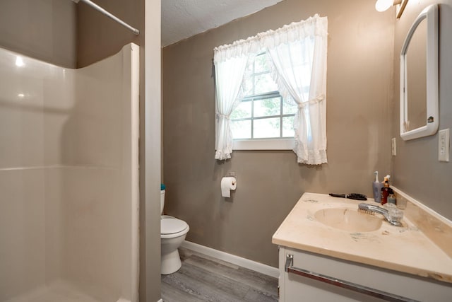 bathroom featuring vanity, toilet, hardwood / wood-style flooring, and a shower