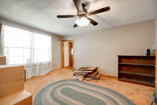 sitting room with a textured ceiling, light colored carpet, and ceiling fan