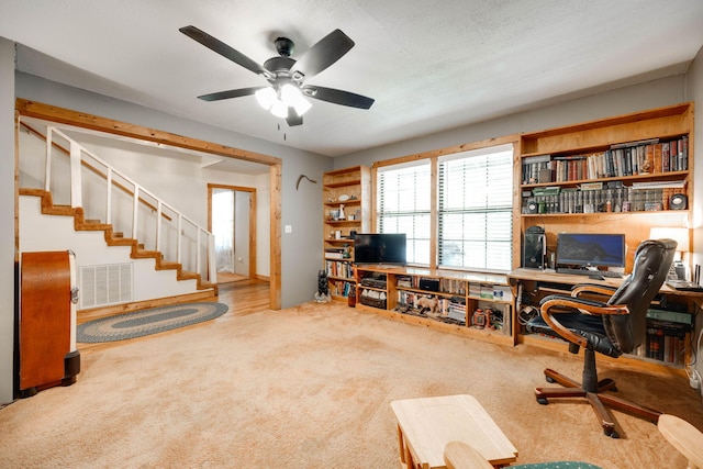 office area with ceiling fan, carpet flooring, and a textured ceiling