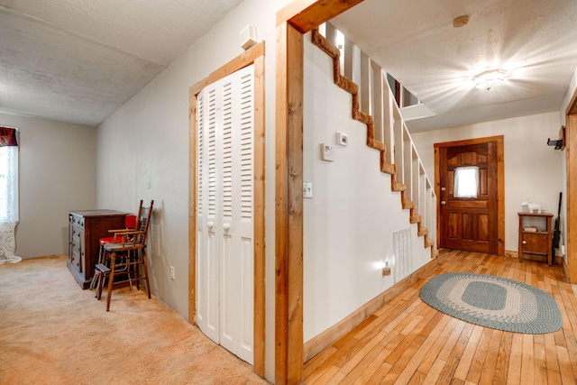 entrance foyer featuring a textured ceiling, light wood-type flooring, and plenty of natural light