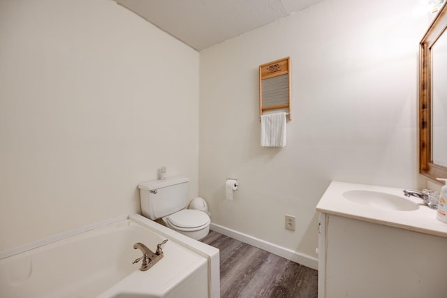 bathroom with vanity, hardwood / wood-style flooring, toilet, and a bathing tub