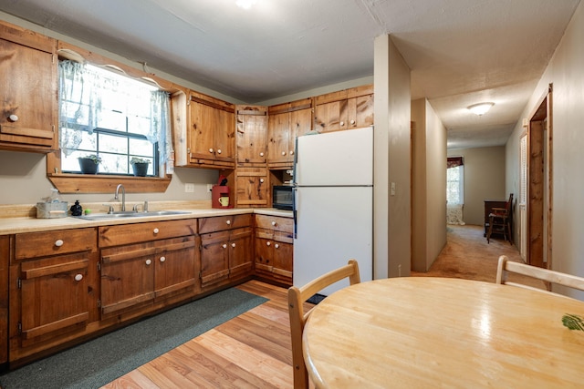 kitchen featuring white fridge, sink, and light wood-type flooring