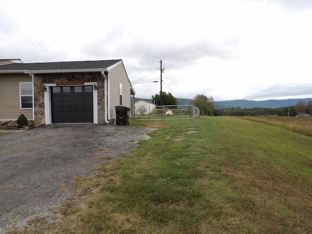 view of property exterior featuring a mountain view, a yard, and a garage