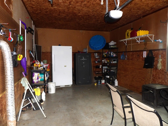 garage with a garage door opener and white refrigerator