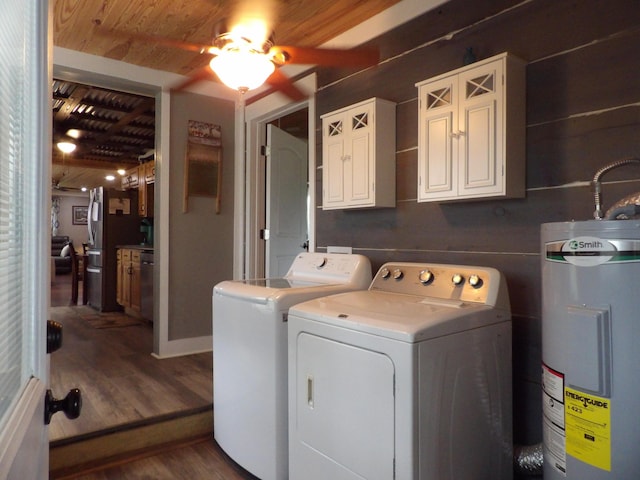 clothes washing area featuring water heater, ceiling fan, separate washer and dryer, dark wood-type flooring, and cabinets