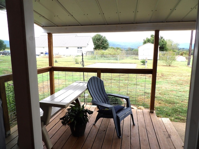 wooden deck featuring a lawn