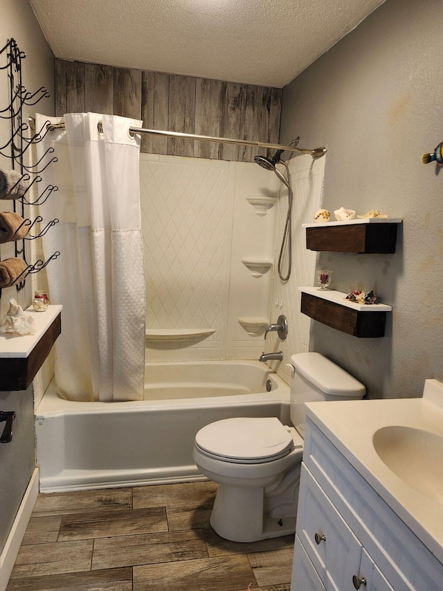 full bathroom featuring toilet, shower / tub combo, vanity, and a textured ceiling