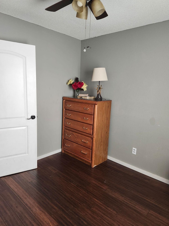 bedroom featuring ceiling fan, dark wood-type flooring, and a textured ceiling