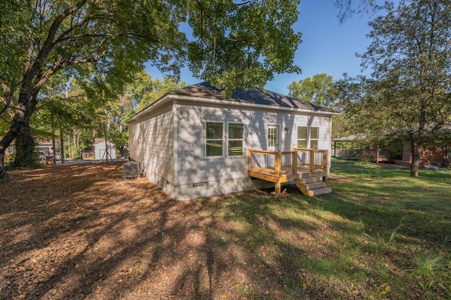 back of property with central AC, a yard, and a wooden deck