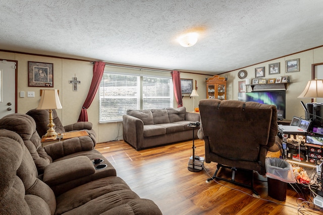 living room featuring light hardwood / wood-style floors, crown molding, and a textured ceiling