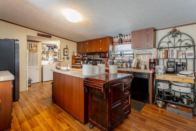 kitchen with stainless steel refrigerator, dishwasher, light hardwood / wood-style floors, washer / clothes dryer, and a textured ceiling