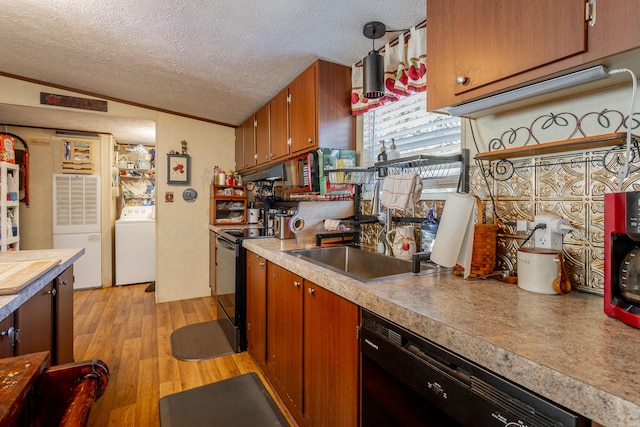 kitchen featuring light hardwood / wood-style floors, sink, washer / dryer, black appliances, and a textured ceiling