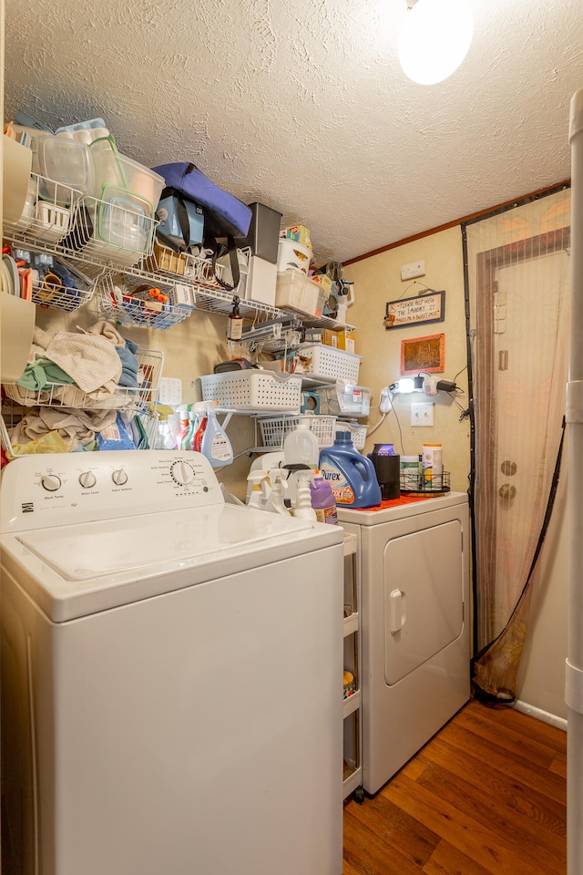 laundry room with a textured ceiling, crown molding, washer and dryer, and dark hardwood / wood-style flooring