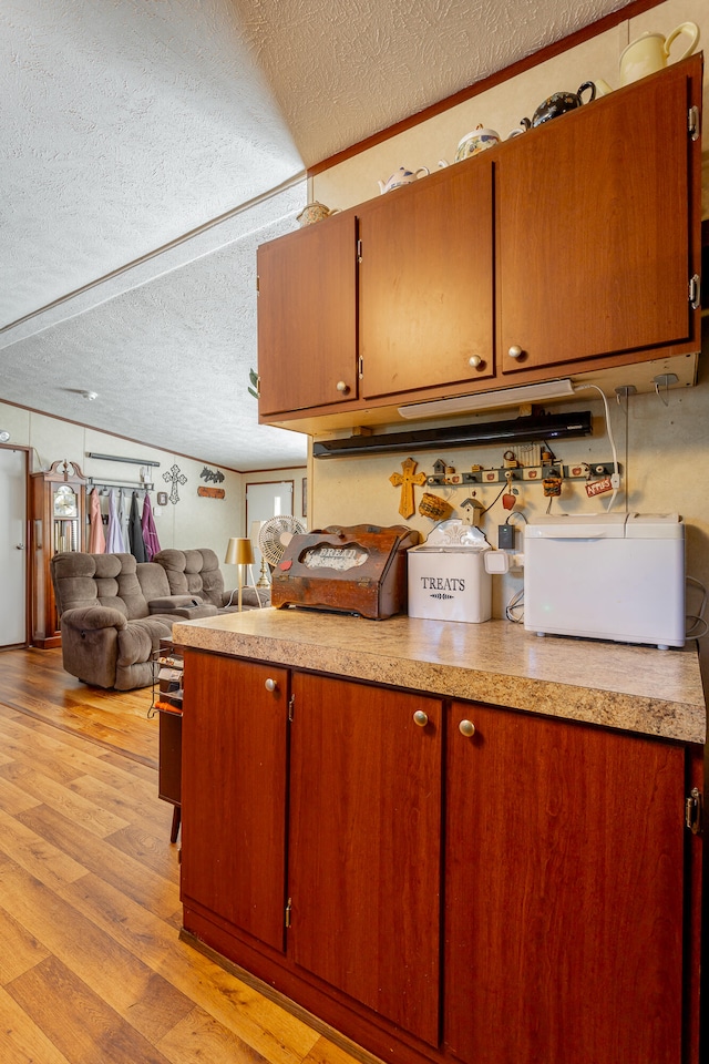 kitchen featuring a textured ceiling and light hardwood / wood-style floors