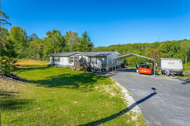 manufactured / mobile home featuring a front lawn and a carport