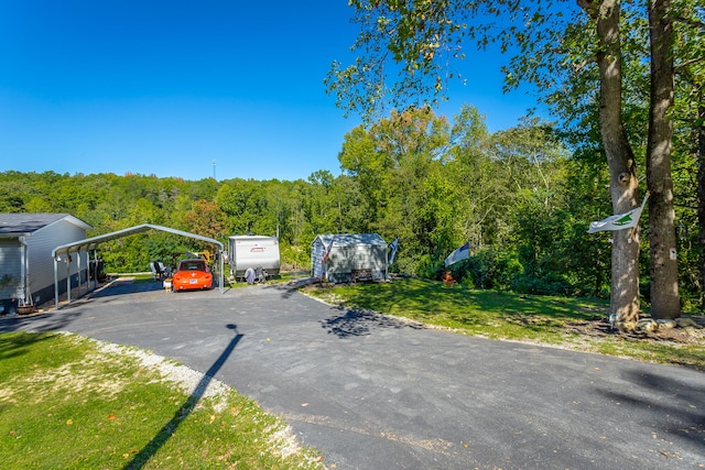 view of vehicle parking with a carport and a lawn