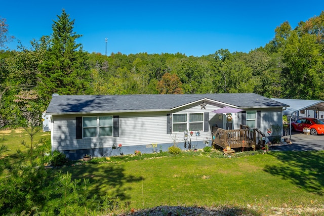 view of front of house featuring a deck, a carport, and a front yard