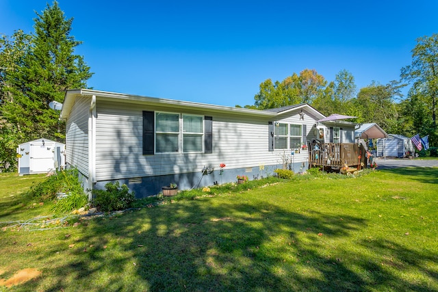 view of front of house featuring a front yard, a deck, and a storage unit