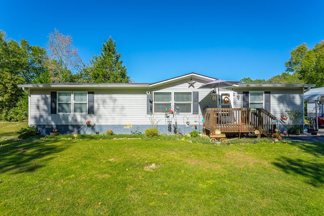 rear view of house with a yard and a wooden deck