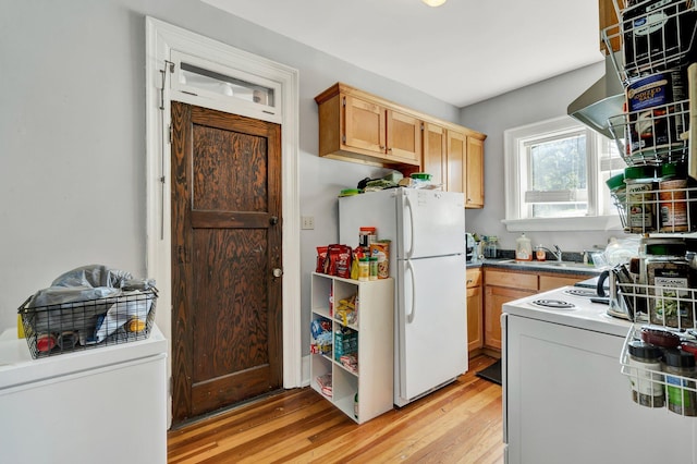 kitchen with range, sink, white fridge, light hardwood / wood-style flooring, and light brown cabinetry