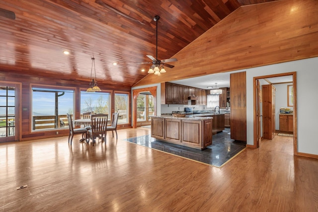 kitchen featuring ceiling fan, pendant lighting, wooden ceiling, dark wood-type flooring, and high vaulted ceiling